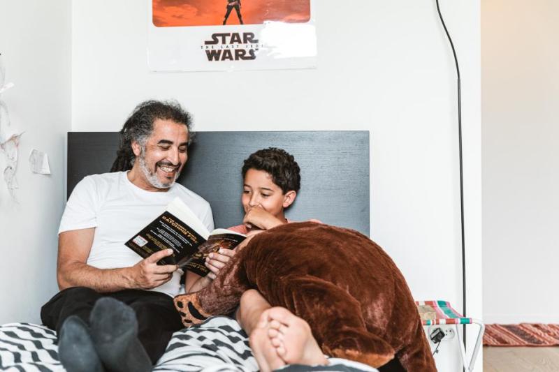 Man leest voor aan jongen in bed