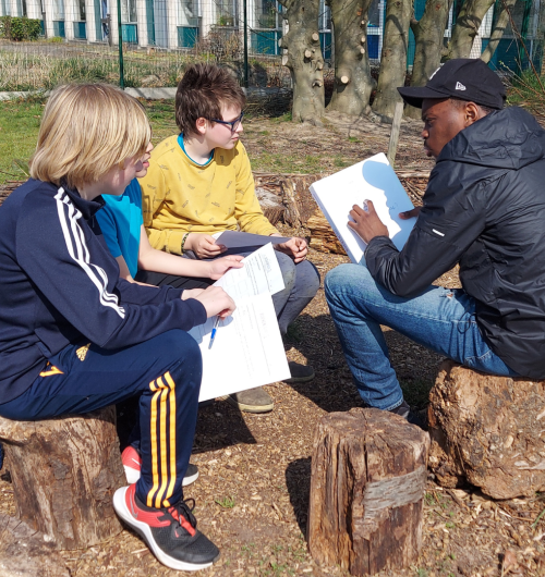 Tiener leest voor aan twee kinderen