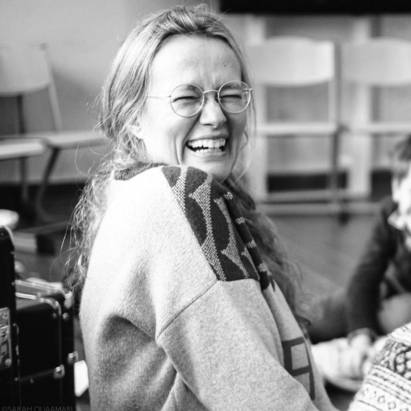 Vrouw met bril die naar de camera lacht
